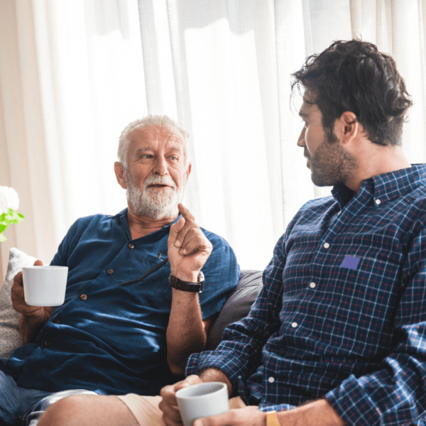 Father and adult son talking over coffee